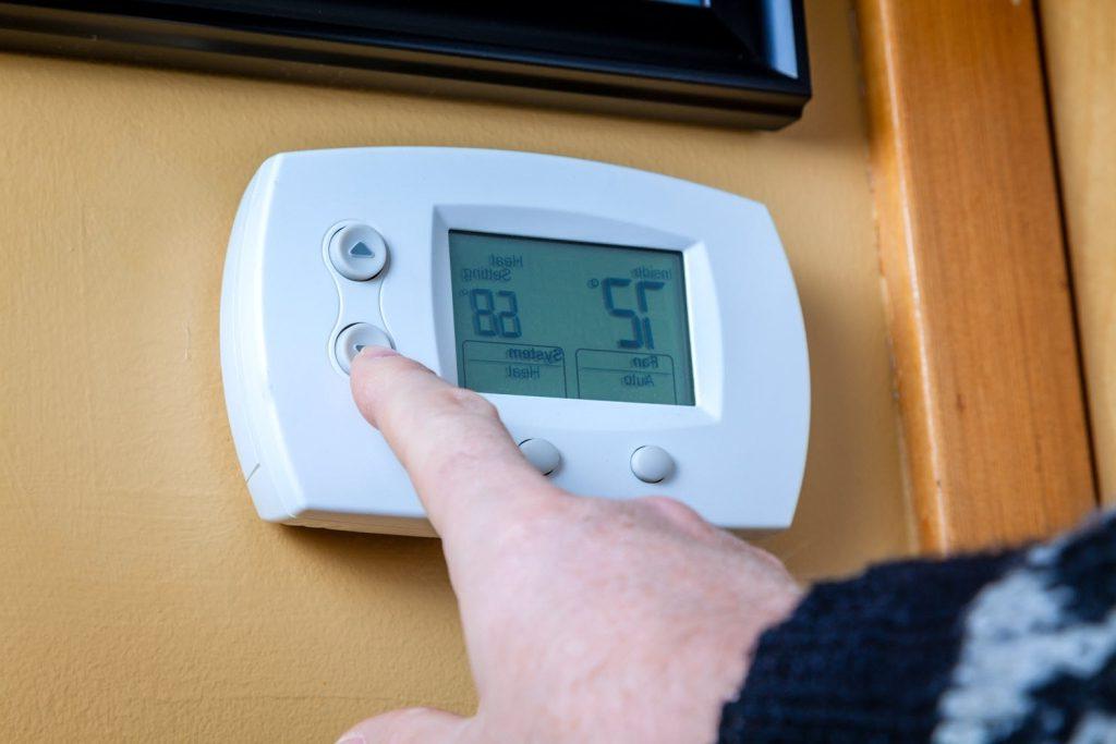 hand on thermostat